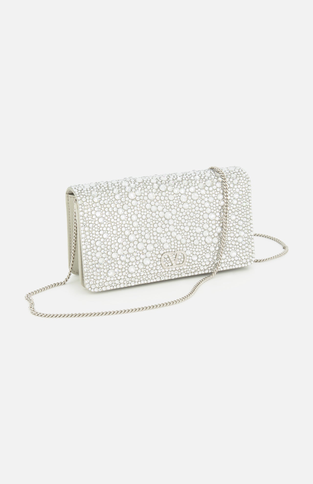 The VALENTINO GARAVANI VLogo Signature Swarovski Crystals Mini Bag is a small, elegant clutch adorned with sparkling Swarovski crystals, featuring a silver chain strap and the iconic metallic VLogo detail on the front—an exquisite accessory perfect for special occasions.