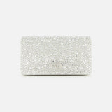 The VALENTINO GARAVANI VLogo Signature Swarovski Crystals Mini Bag exudes effortless elegance with its rectangular white silhouette, adorned in shimmering Swarovski crystals and lustrous pearls. Set against a plain white background, this exquisite silver mini bag captures the light with every detail, making it the perfect special occasion accessory.