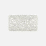 The VALENTINO GARAVANI VLogo Signature Swarovski Crystals Mini Bag, a rectangular silver clutch adorned with shimmering Swarovski crystals, is displayed against a plain white background, making it the perfect accessory for special occasions.