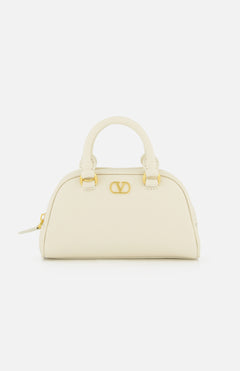The VALENTINO GARAVANI VLogo Signature Mini Dome Bag in ivory grained leather features two handles, gold hardware, and a bold front gold VLogo accent, shown against a plain white background.