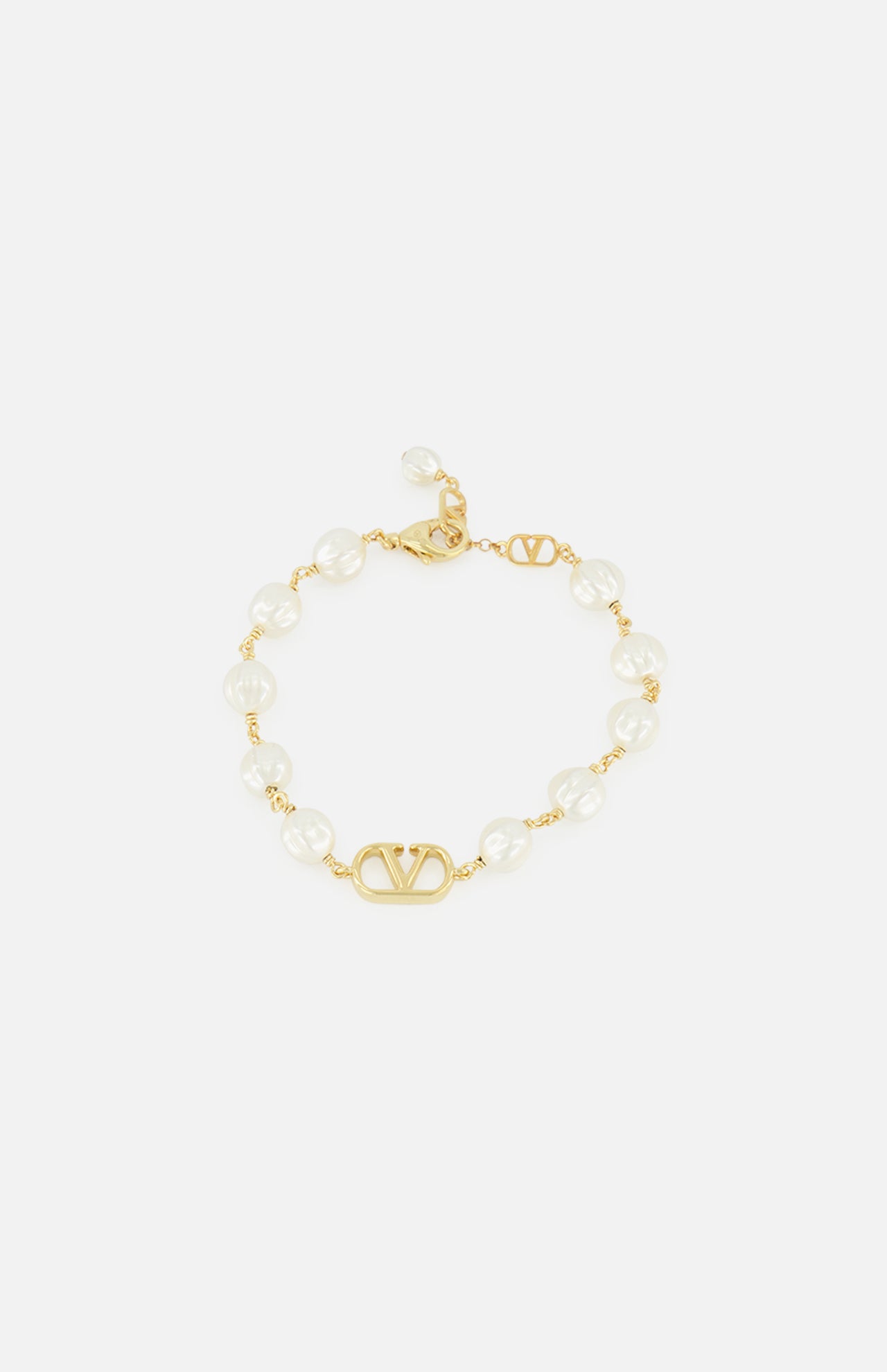 The VALENTINO GARAVANI VLogo Signature Pearl Bracelet features gold-tone links, alternating white pearls and glass beads, a central gold VLogo, and an adjustable clasp.