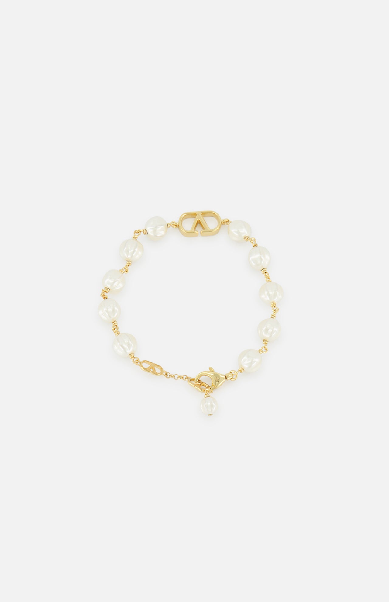 VALENTINO GARAVANI VLogo Signature Pearl Bracelet featuring a gold-tone logo accent at the center, with glass beads and a gold clasp. Photographed on a plain white background.