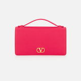A vibrant pink rectangular VALENTINO GARAVANI VLogo Signature Wallet with Strap, featuring a top handle and a striking gold VLogo emblem on the front, displayed against a plain white background.
