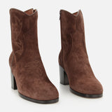 The Zimmy Western Bootie by VALENTINO GARAVANI features dark brown suede with decorative stitching, rounded toes, and chunky high heels. These boots are designed with side zippers and a subtle western-inspired look, offering a stylish update on classic western boots.