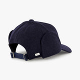The Legacy Structured Merino Wool Earflap Hat by VARSITY HEADWEAR is shown in navy blue, featuring an adjustable back strap and a small silver rectangular tag on the back, set against a plain white background.