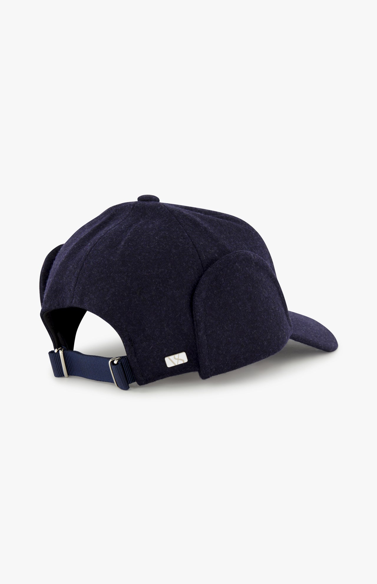 The Legacy Structured Merino Wool Earflap Hat by VARSITY HEADWEAR is shown in navy blue, featuring an adjustable back strap and a small silver rectangular tag on the back, set against a plain white background.