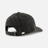 The Legacy Structured Oilskin Highland Hat by VARSITY HEADWEAR, featuring a black and gray plaid tartan pattern, is shown from the back with an adjustable strap and metal buckle, set against a plain light gray background.