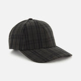 The Legacy Structured Oilskin Highland Hat by VARSITY HEADWEAR features a dark tartan plaid pattern, a curved brim, and an adjustable back strap, and is displayed against a plain white background.