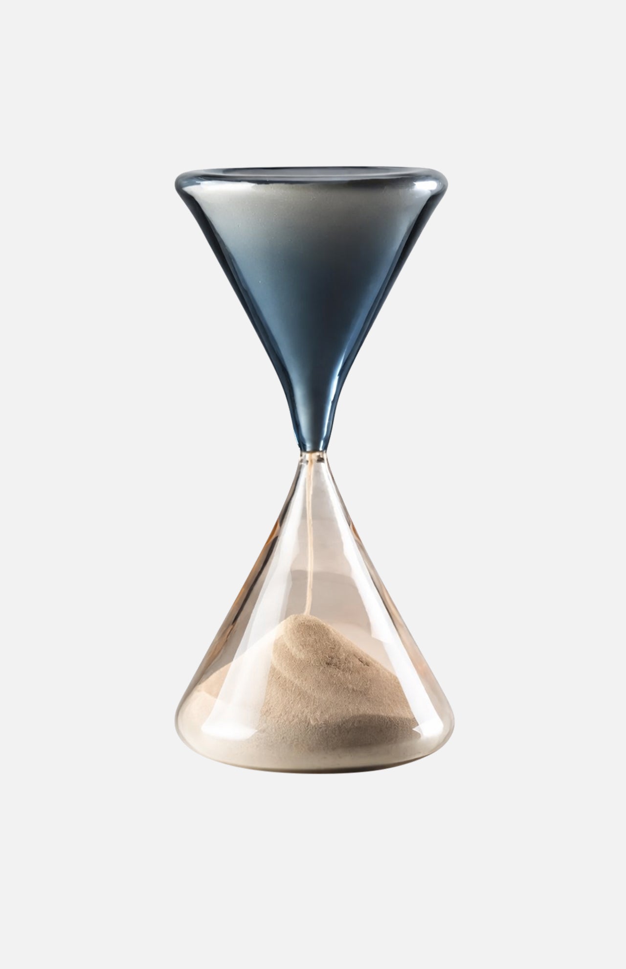 The VENINI Clessidra Hour Glass features a Murano glass design with a dark blue top, clear bottom, and light sand settled below, displayed against a plain white background.