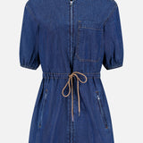 The Akerman Denim Mini Dress by VERONICA BEARD is shown against a plain white background, featuring a zip front, short sleeves, knee-length cut, drawstring waist, chest pocket, and two zippered side pockets.