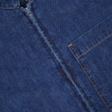 Close-up of the Akerman Denim Mini Dress by VERONICA BEARD, featuring a visible zipper, chest pocket, brown stitching, and a partial VERONICA BEARD label at the neckline.