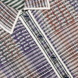 Close-up of the VERONICA BEARD Lauper Tweed-like Mini Dress, featuring a purple, red, and white houndstooth pattern, black buttons, and white trim along the collar and button placket. Brand label is visible.