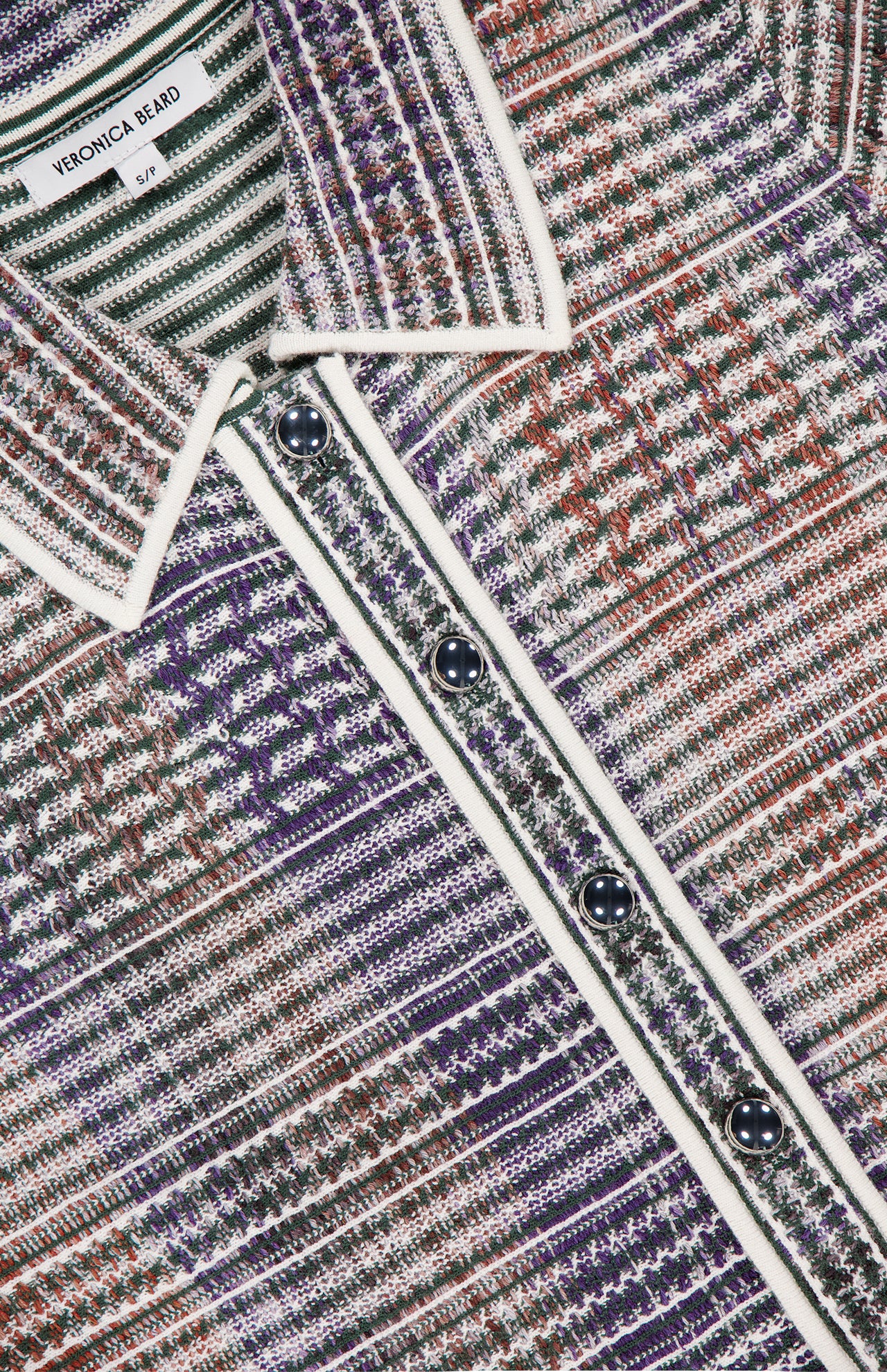 Close-up of the VERONICA BEARD Lauper Tweed-like Mini Dress, featuring a purple, red, and white houndstooth pattern, black buttons, and white trim along the collar and button placket. Brand label is visible.