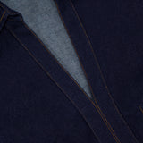 Close-up of the Raymond Denim Mini Dress by VERONICA BEARD, featuring dark blue denim, orange stitching, a fit-and-flare silhouette, and a partially visible brand label at the neckline.