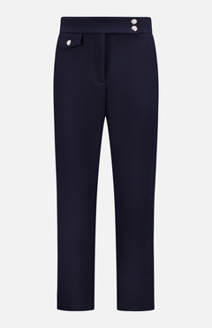 The Renzo Pant by VERONICA BEARD features a navy blue straight-leg fit, two decorative silver buttons on the waistband, and a flap detail on one side, shown against a plain white background.