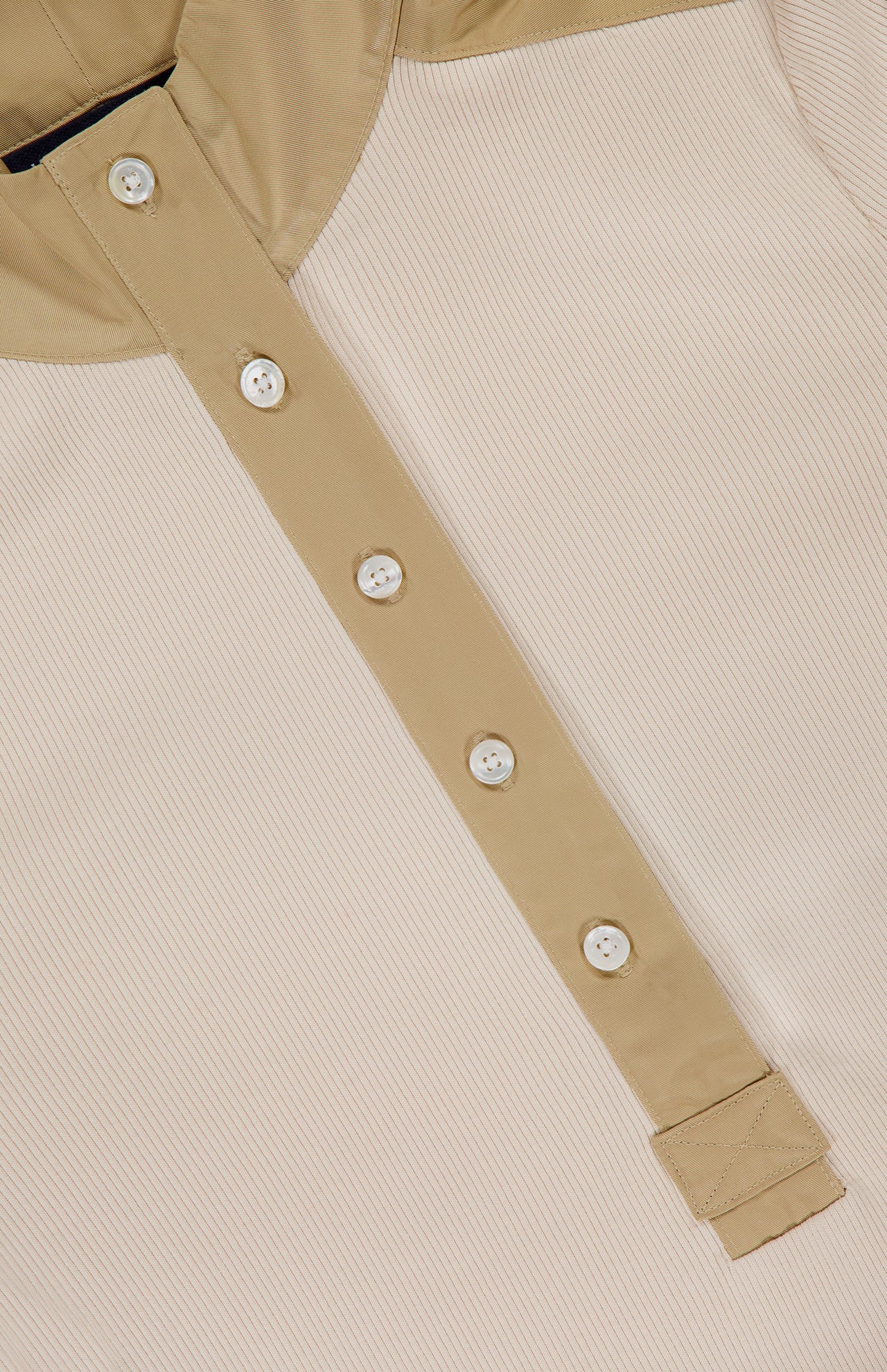 Close-up of the VERONICA BEARD Reynart Contrast Trim Top, featuring a beige ribbed texture and five-button placket. The collar and placket stand out in contrasting tan, making it an ideal base layer with stylish details.