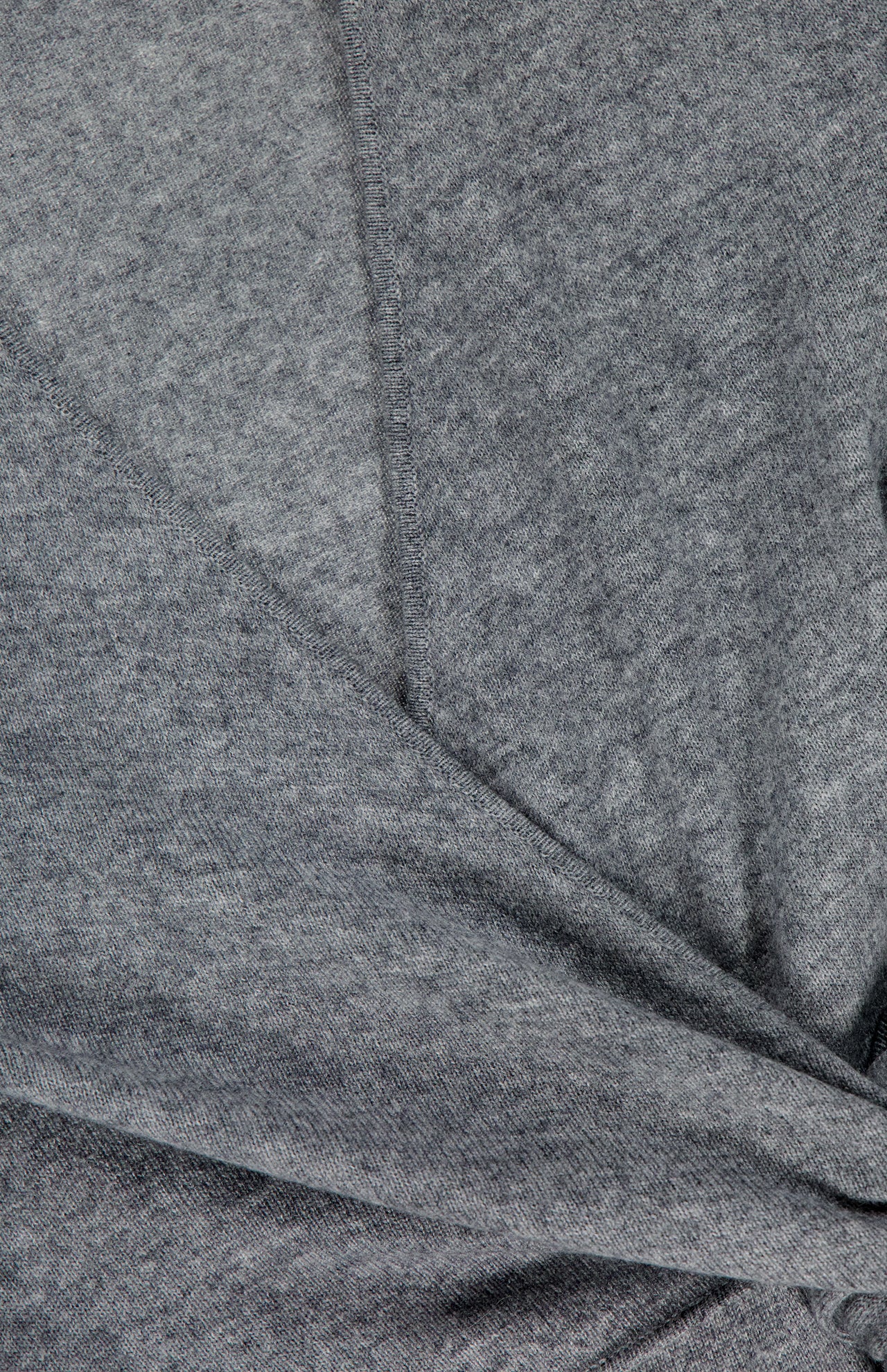 Close-up of the Salomez Knit Wrap Dress by VERONICA BEARD in soft heather gray merino wool, highlighting the fabric's texture, visible stitching, and a gentle fold at the hem.