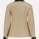 The VERONICA BEARD Talla Water Repellant Jacket in beige features a contrasting black collar, black cuff straps and buttons, tailored seams, and a modern back view—perfect for stylish weather-ready looks.