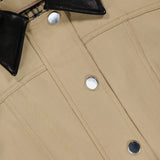 Close-up of the VERONICA BEARD Talla Water Repellant Jacket in khaki, featuring silver snap buttons, a black leather collar, and a visible brand label inside the neckline.
