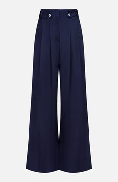 The VERONICA BEARD Allman Wide Leg Button Tab Pant features a high waist, front pleats, belt loops, and button accents at the waistband. These versatile navy women’s cotton pants are showcased against a plain white background.