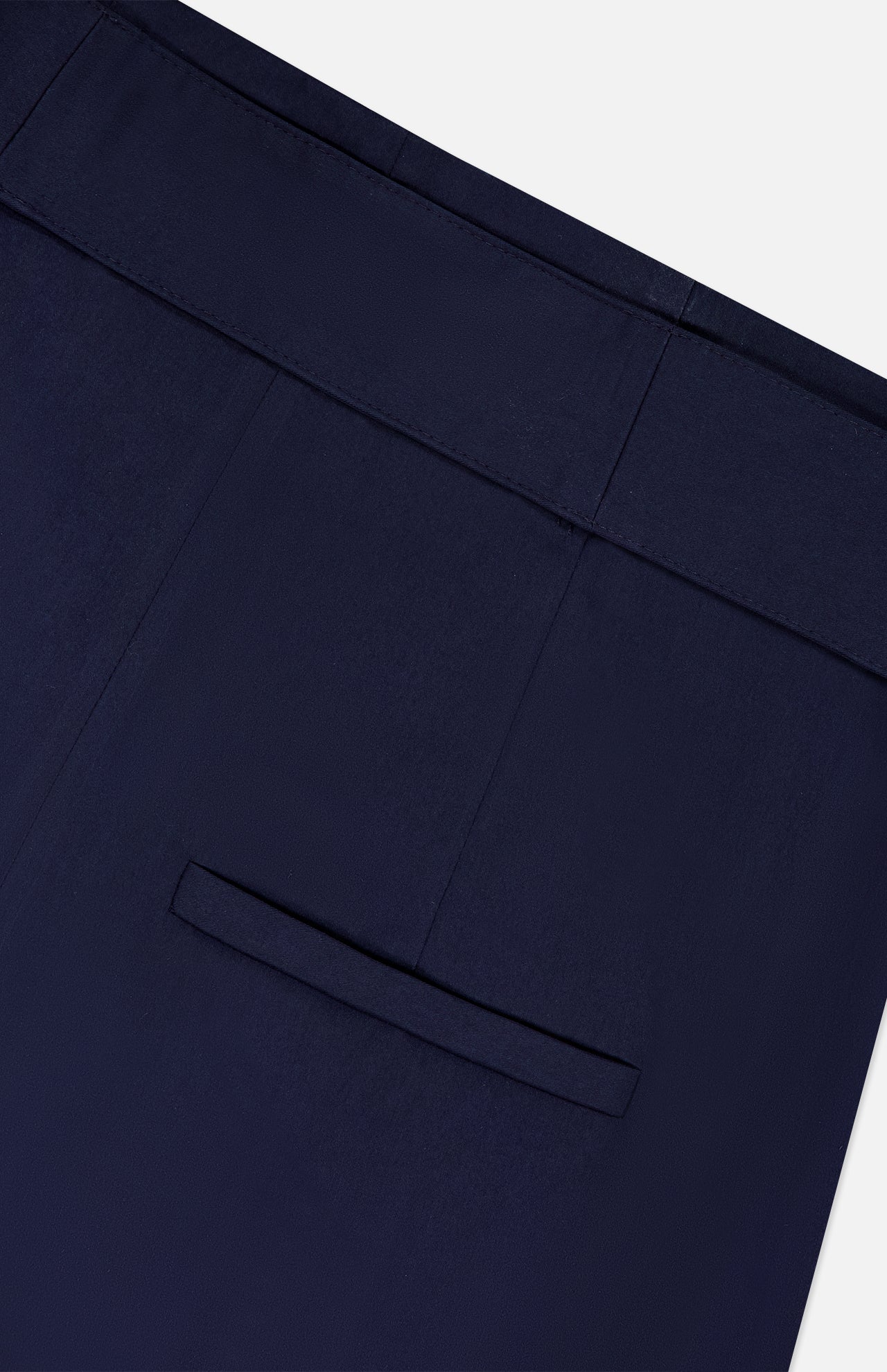 Close-up of VERONICA BEARD's Allman Wide Leg Button Tab Pant in navy, highlighting the single back welt pocket and detailed waistband against a plain white background.