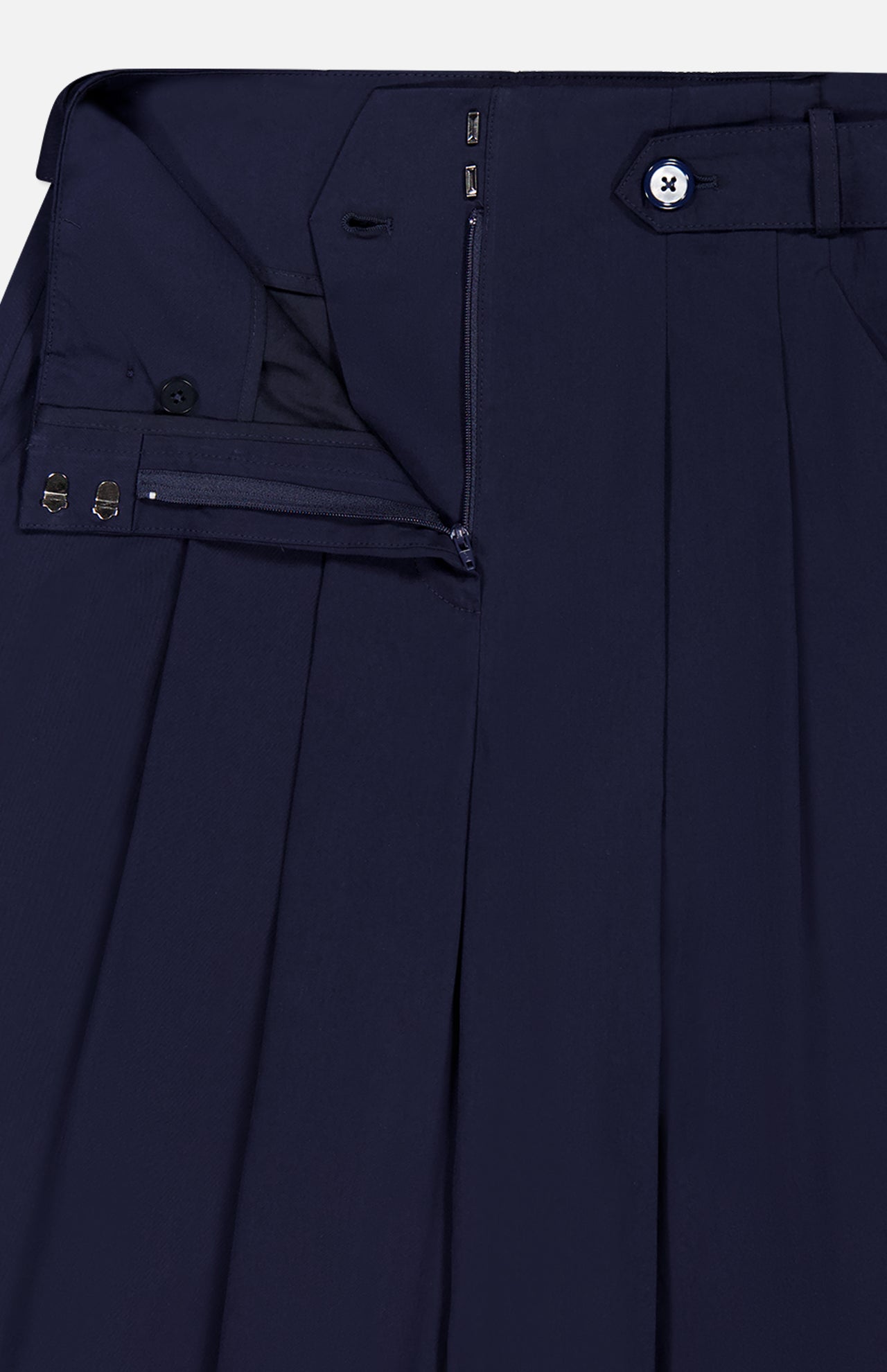 Close-up of VERONICA BEARD's Allman Wide Leg Button Tab Pant in navy cotton, showcasing the neatly pressed waistband, pleats, button tab, zipper, and metal hook-and-bar closures with partial unfastening to highlight refined details.