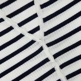 Close-up of the Anwin Scallop Trim Cardigan by VERONICA BEARD, featuring white ribbed fabric with evenly spaced horizontal black stripes and intersecting seams for a classic look.