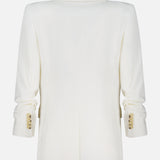 The Battista Dickey Jacket by VERONICA BEARD is a white blazer with long sleeves, gold cuff buttons, and a center seam detail. Crafted with stretch tailoring for enhanced comfort. Shown from the back.