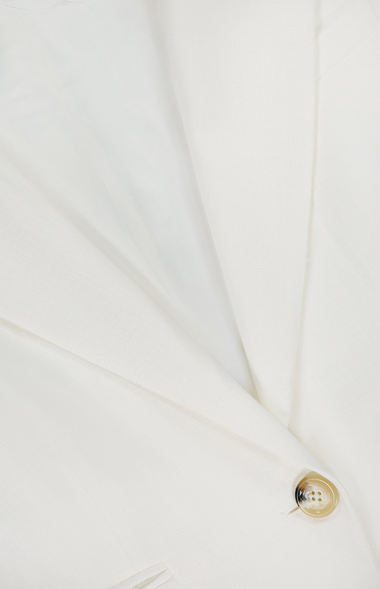 Close-up of the VERONICA BEARD Battista Dickey Jacket, a white blazer featuring a smooth, tailored finish, classic lapel, buttonhole detail, and a single beige button.
