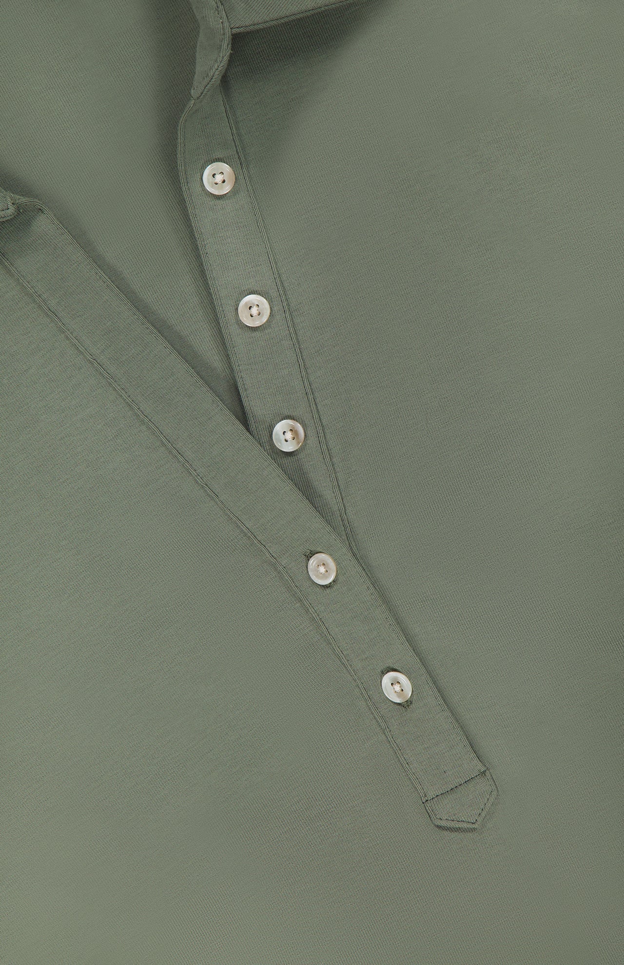 A close-up of the VERONICA BEARD Besser Ruched Polo Dress in olive green micro-rib stretch cotton, featuring a partially unbuttoned placket with four white buttons, highlighting the fabric texture and stitching details.
