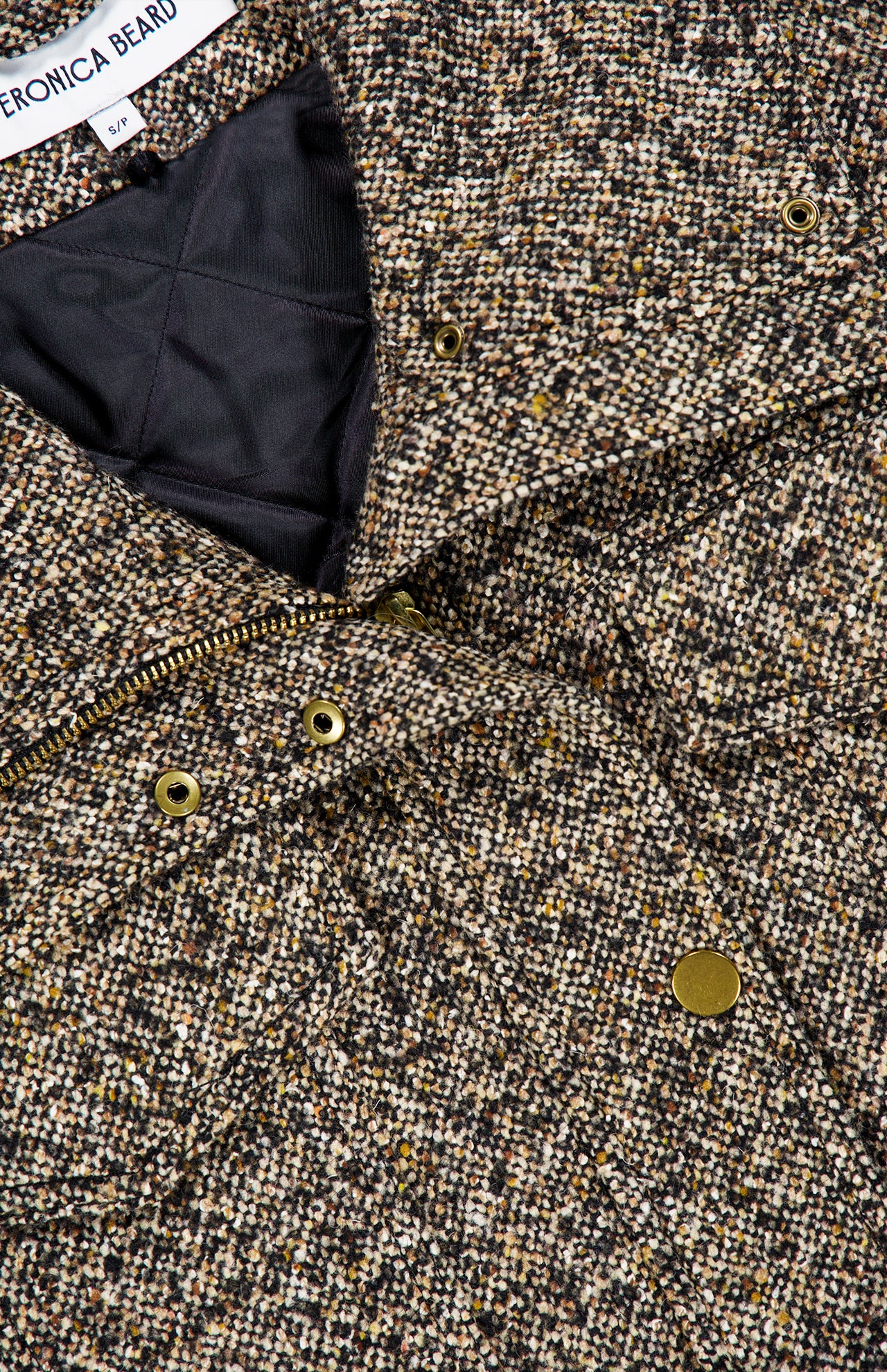 Close-up of the Tweed Butler Dickey Jacket by VERONICA BEARD, featuring textured brown tweed, gold snap buttons, a zipper, and quilted black lining. This ladylike jacket is dickey compatible for versatile styling options in your wardrobe.