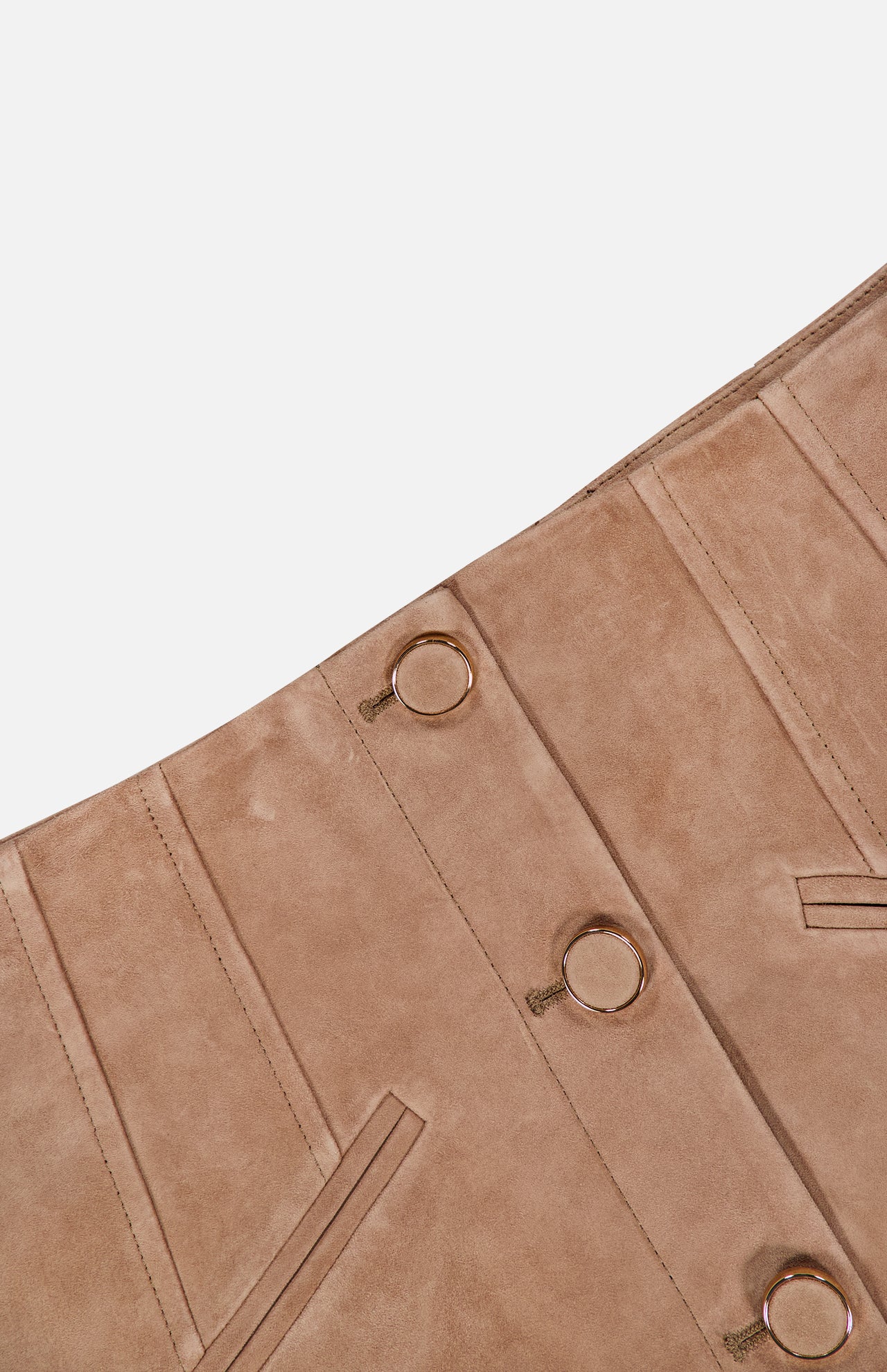 Close-up of the Callisian Leather Midi Skirt by VERONICA BEARD, crafted from tan lambskin suede with seam details, gold ring buttons, and two slanted front pockets, set against a white background.