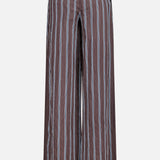 The Carraway Pant by VERONICA BEARD features a brown wide-leg design with vertical light blue and white textured stripes, two back welt pockets, an elastic waistband, and a high-rise fit. Shown against a plain white background.