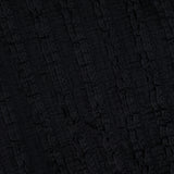 Close-up of the textured black fabric of the Charissa Ruched Mini Dress by VERONICA BEARD, featuring a vertically wavy, crinkled pattern—perfect for adding unique detail to this body-sculpting silhouette.
