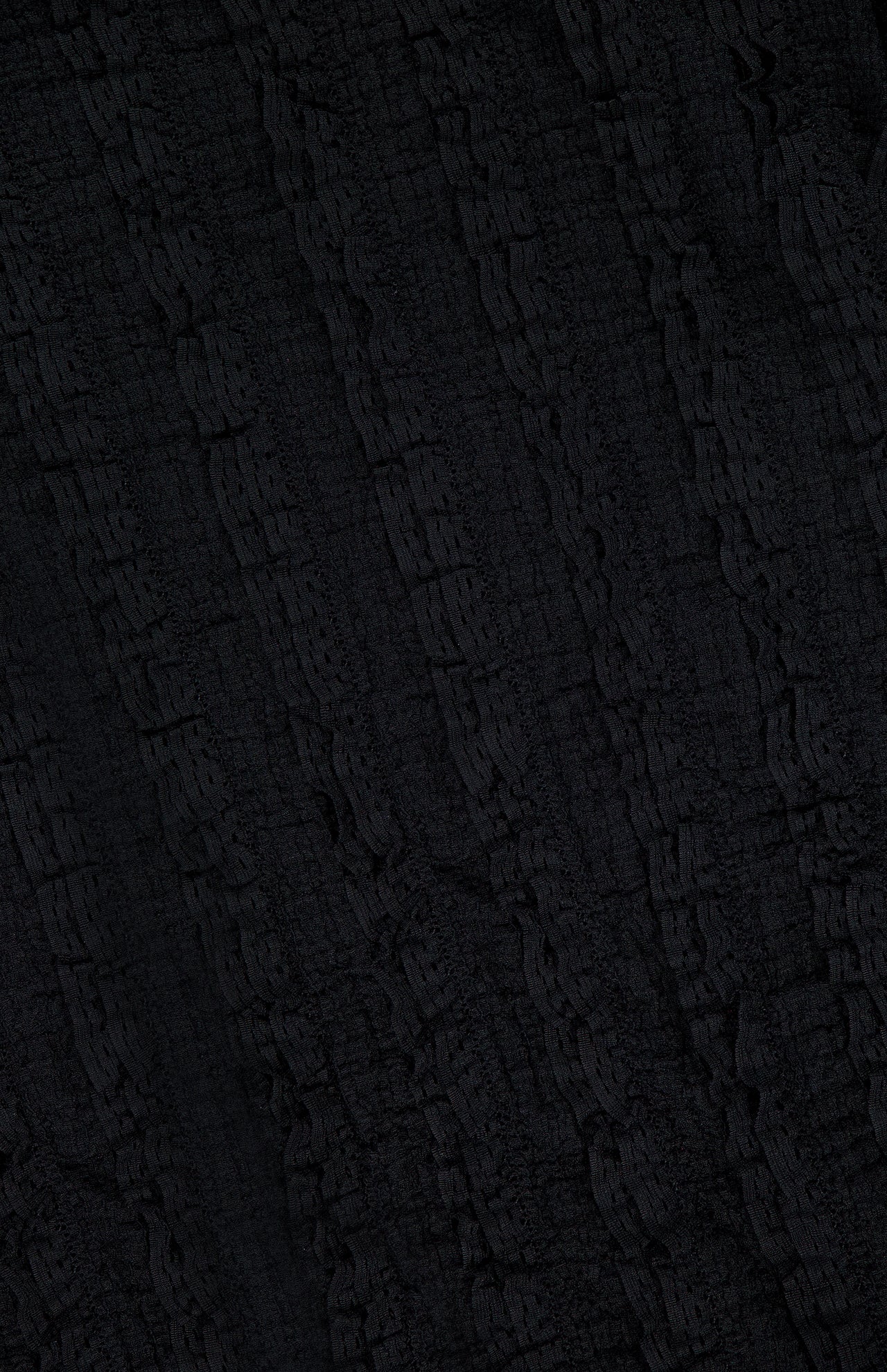 Close-up of the textured black fabric of the Charissa Ruched Mini Dress by VERONICA BEARD, featuring a vertically wavy, crinkled pattern—perfect for adding unique detail to this body-sculpting silhouette.