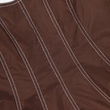 Close-up of the Charlie Corset-inspired Top by VERONICA BEARD in mocha brown stretch cotton poplin, featuring vertical curved white contrast stitching and a glimpse of the neckline with a smooth texture.