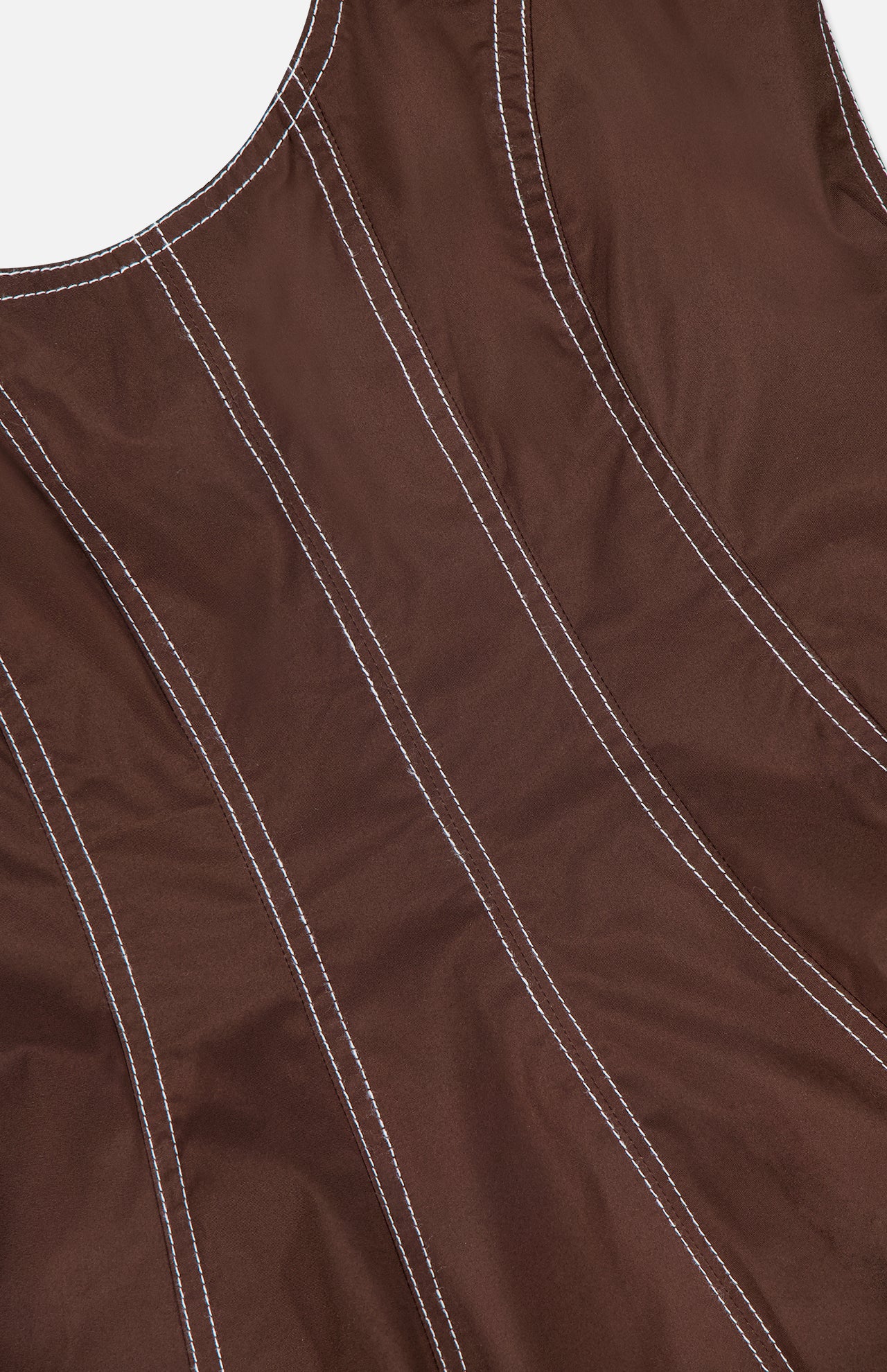 Close-up of the Charlie Corset-inspired Top by VERONICA BEARD in mocha brown stretch cotton poplin, featuring vertical curved white contrast stitching and a glimpse of the neckline with a smooth texture.
