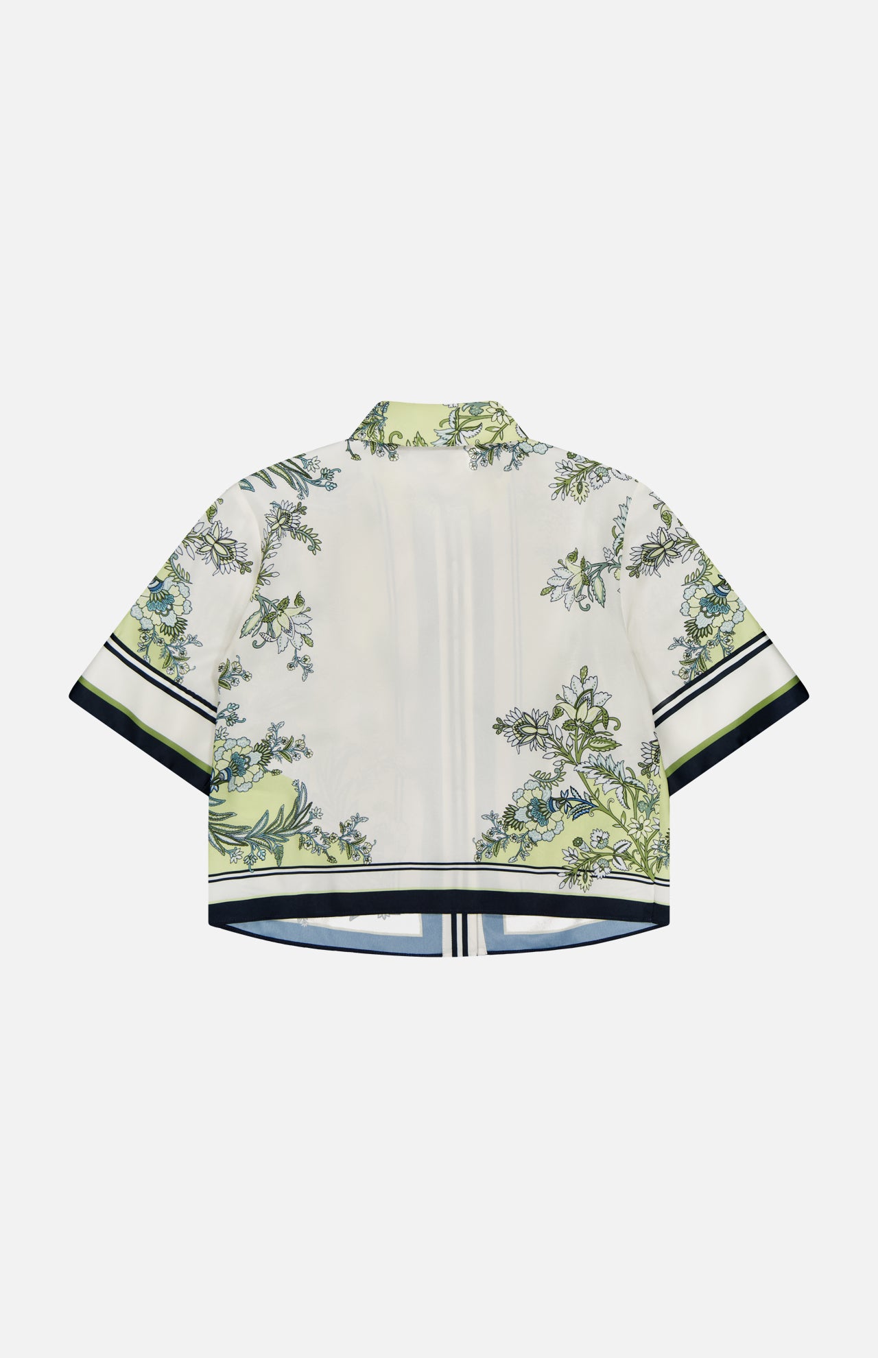 The Clean Spruce Cropped Top by VERONICA BEARD is a short-sleeved, boxy fit shirt in light cream with green and blue botanical print, featuring black and white striped trim on the sleeves and hem. Back view shown.