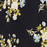 The Clover Floral Midi Skirt by VERONICA BEARD features black stretch georgette adorned with white and blue floral clusters and green leaves—a chic option for an elegant midi or slip skirt look.