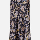 The VERONICA BEARD Clover Paisley Midi Skirt is a sleek black satin slip skirt adorned with ornate paisley floral patterns in gold, beige, and light blue.