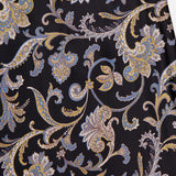 A close-up of the Clover Paisley Midi Skirt by VERONICA BEARD, showcasing its intricate blue, gold, and white paisley pattern with swirling floral and leaf motifs on a black silk background.