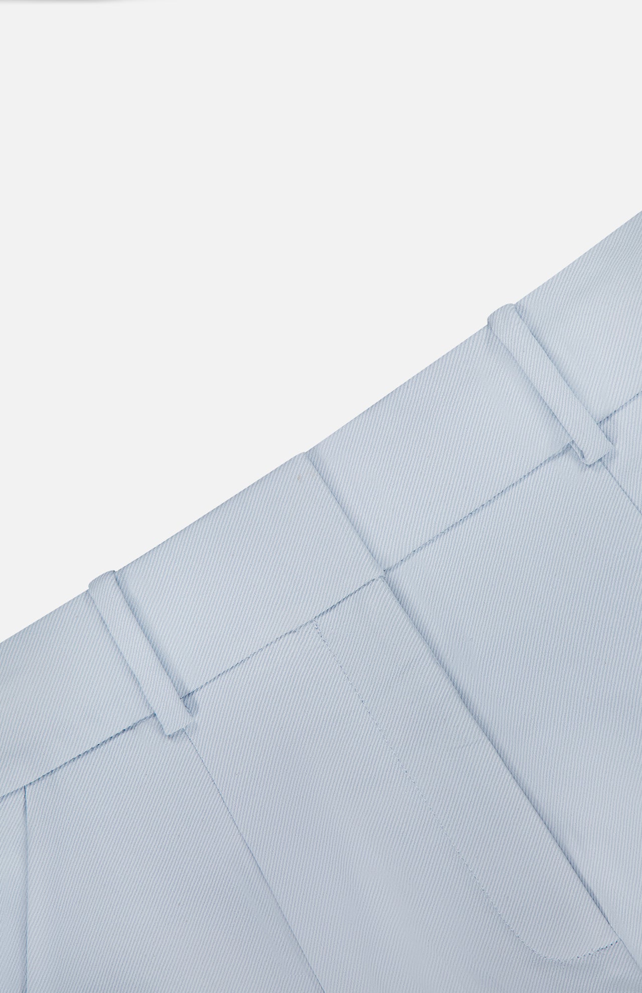 Close-up of the Craig High Rise Short by VERONICA BEARD in light blue Italian cotton-blend twill, featuring the waistband, belt loops, and upper front pockets against a plain white background.