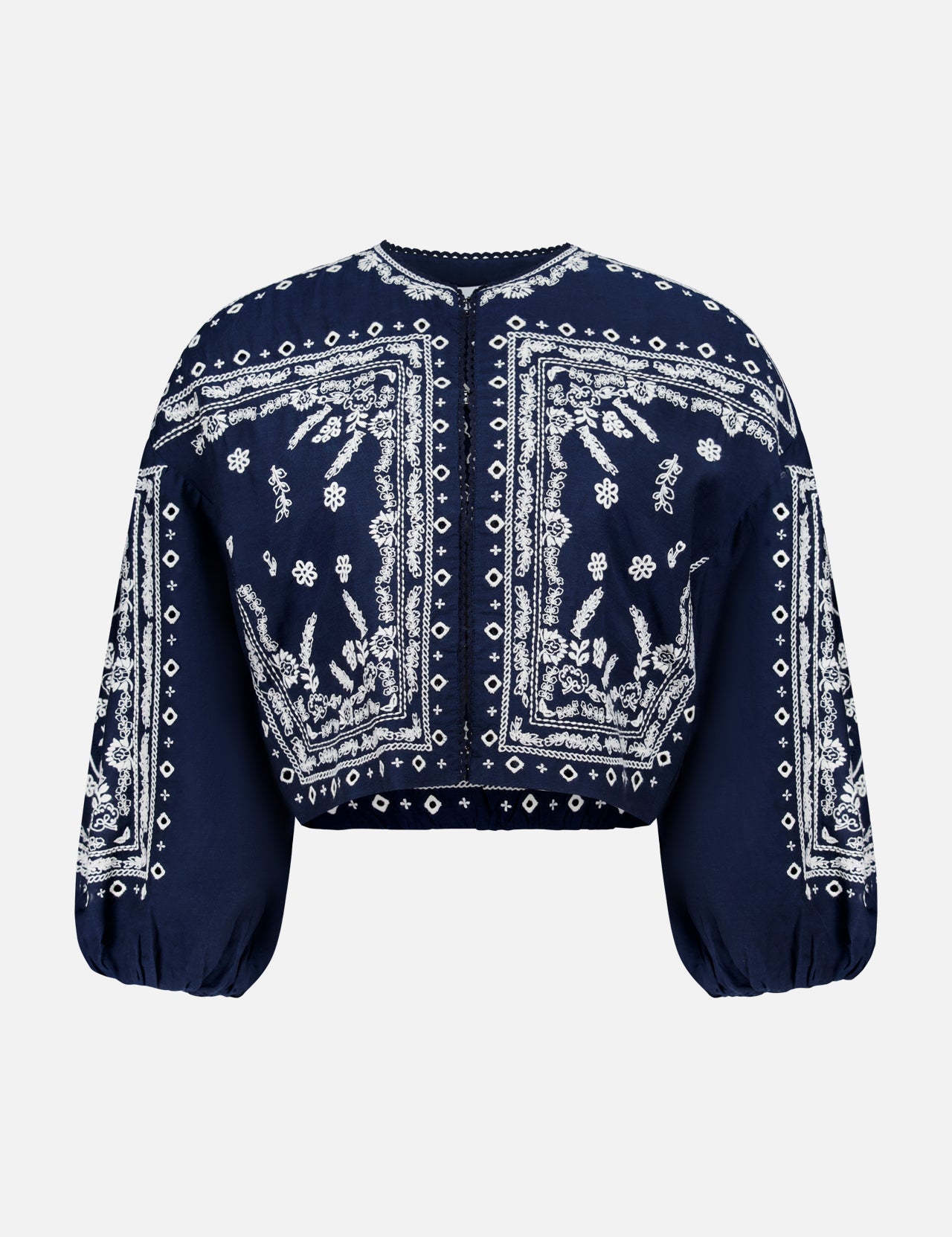 The Drake Embroidered Balloon Sleeve Jacket by VERONICA BEARD is a navy blue cropped blouse with white paisley and floral bandana-style embroidery, round neckline, and loose, gathered balloon sleeves.