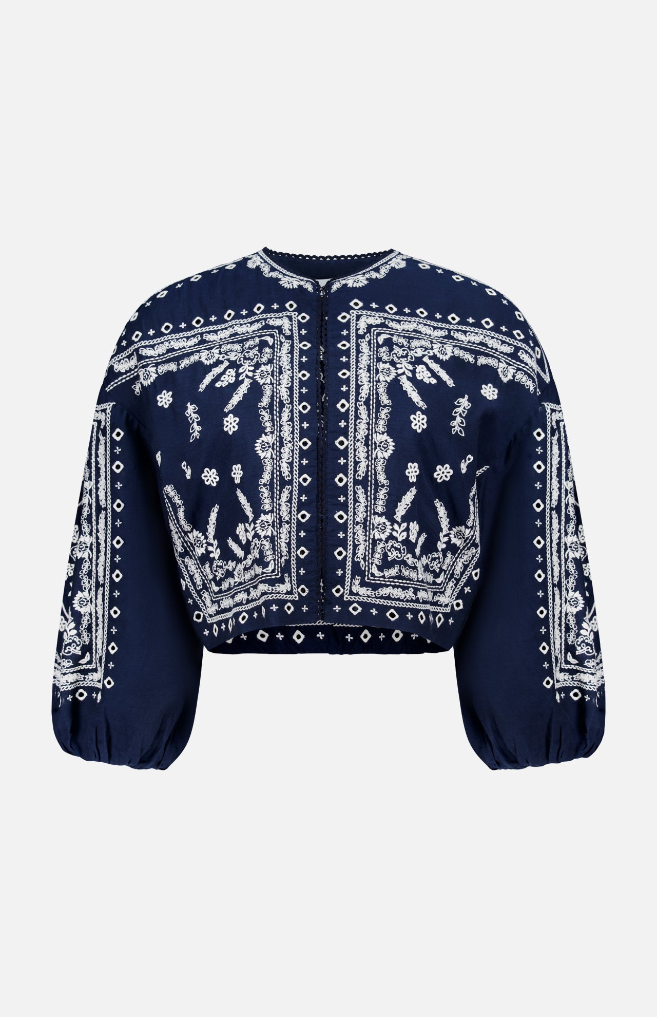 The Drake Embroidered Balloon Sleeve Jacket by VERONICA BEARD is a navy blue cropped blouse with white paisley and floral bandana-style embroidery, round neckline, and loose, gathered balloon sleeves.