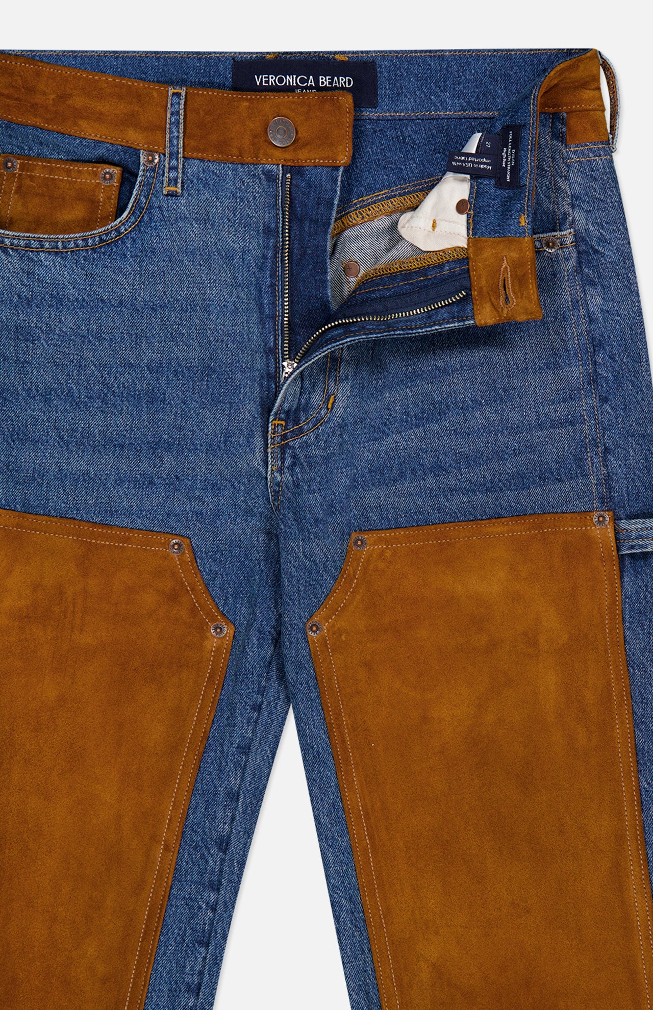 A pair of VERONICA BEARD Dylan High Rise Straight Leg Jeans in blue denim, featuring brown suede patches and trim, partially unzipped to show the inner white pocket lining, with the brand label visible on the waistband.