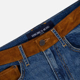 Close-up of the Dylan High Rise Straight Leg Jean by VERONICA BEARD, featuring blue denim with brown suede panels on the waistband and belt loops. The interior waistband displays a sewn-in VERONICA BEARD label. Expertly crafted, these high-rise straight-leg jeans offer both style and comfort.