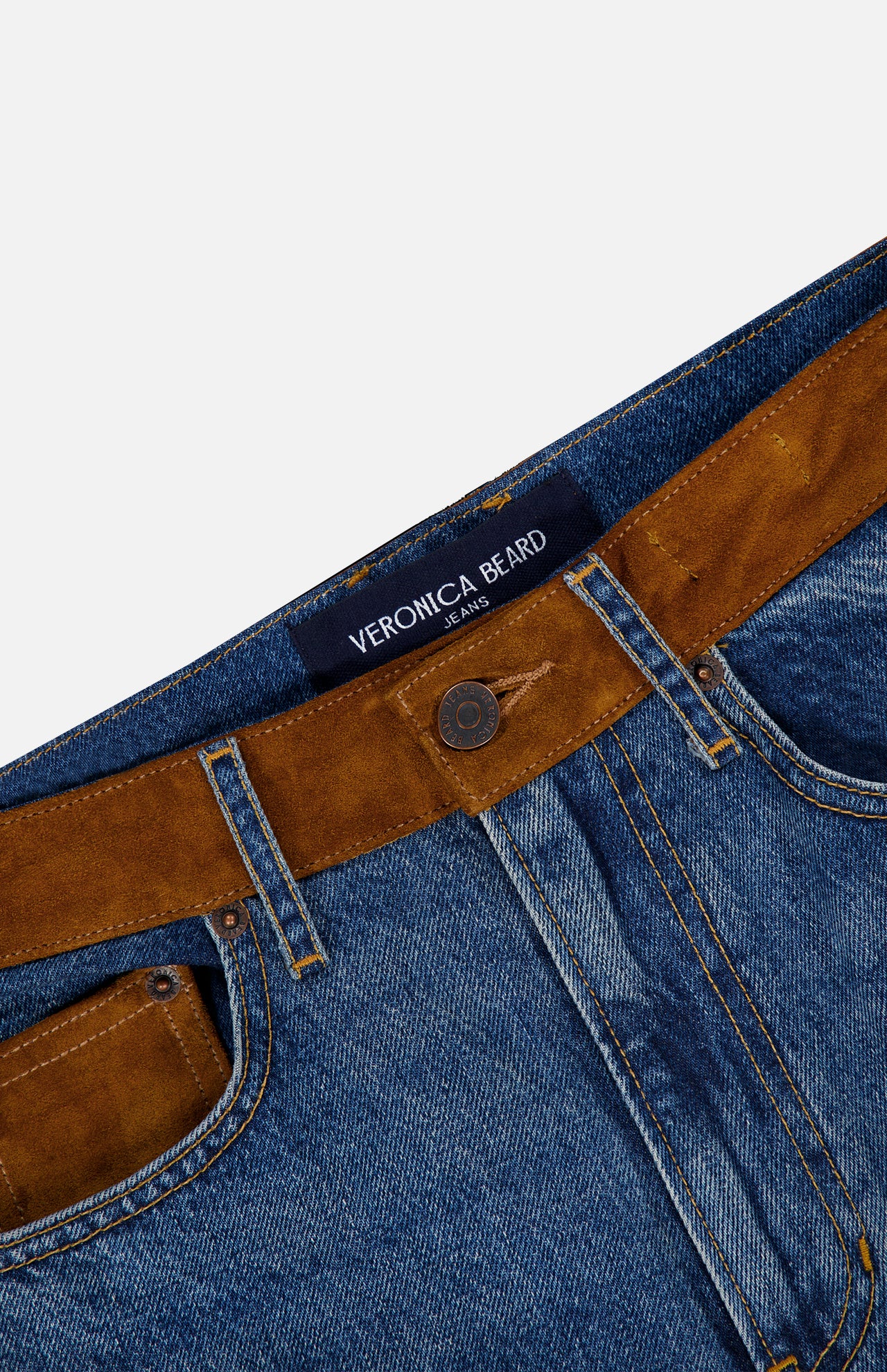 Close-up of the Dylan High Rise Straight Leg Jean by VERONICA BEARD, featuring blue denim with brown suede panels on the waistband and belt loops. The interior waistband displays a sewn-in VERONICA BEARD label. Expertly crafted, these high-rise straight-leg jeans offer both style and comfort.