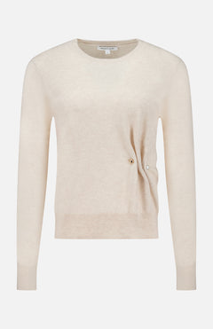 The Frankie Pearl Pin Pullover Sweater by VERONICA BEARD is a long-sleeved, light beige neutral sweater with a round neckline. Crafted from soft merino wool, it features a subtle ribbed hem and cuffs, along with a distinctive small pearl pin detail on the right side near the waist, offering both comfort and timeless elegance.