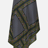 The Hartley Scarf Print Skirt by VERONICA BEARD is an asymmetrical silk midi skirt featuring a geometric and floral pattern in blue, green, yellow, and white, accented with small dots and swirling designs on a white background.
