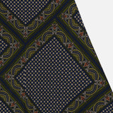 The Hartley Scarf Print Skirt by VERONICA BEARD showcases a dark fabric adorned with a repeating geometric and paisley-inspired motif: small circles nestled within diamond shapes, bordered by intricate curved patterns in navy, gold, olive, and subtle accents of red—an eye-catching design perfect for an elegant silk midi skirt.